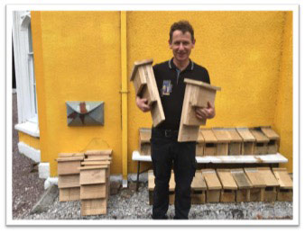 Donal Hayes with bat boxes made by The Men's Shed